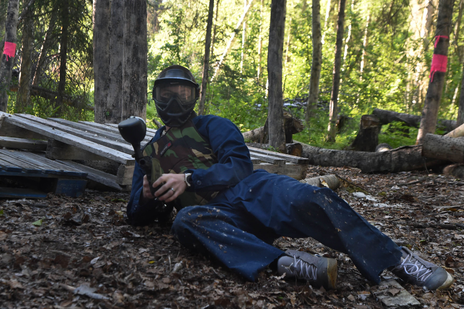 Player taking cover on the ground during a paintball game